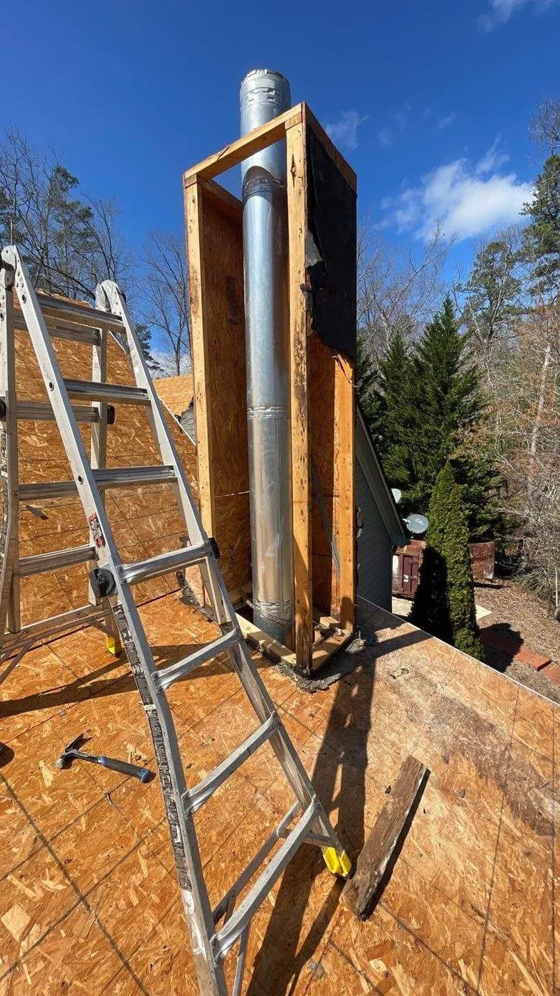 New flue and metal shroud being installed during a chimney rebuild by Platinum Roofing