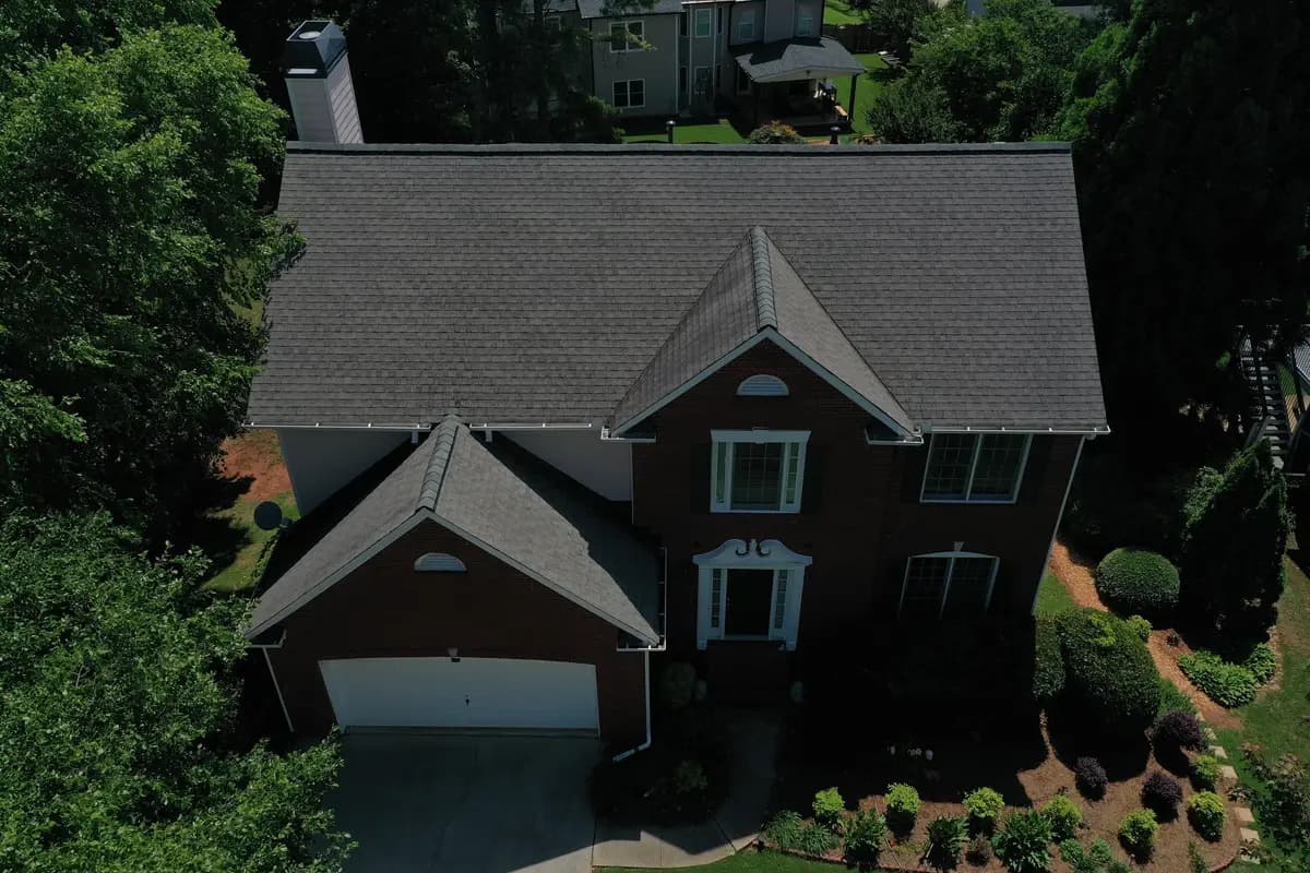 Aerial view of a brick home with a dark shingle roof in Alpharetta, GA