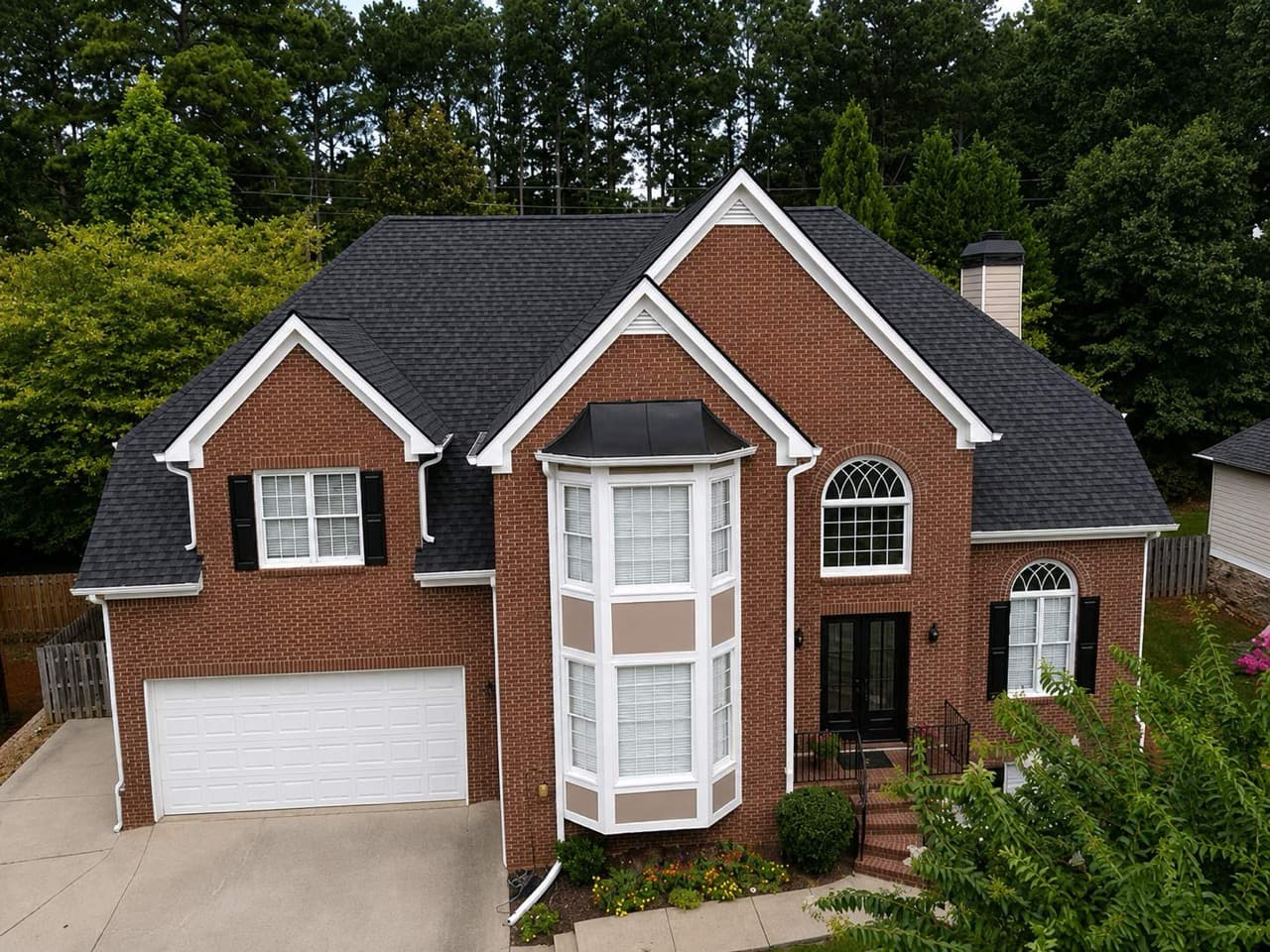 A North Georgia brick home with a healthy architectural asphalt shingle roof installed by Platinum Roofing