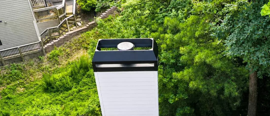 Aerial close-up of a new black chimney shroud and metal chimney pan capping a framed chimney chase, installed by Platinum Roofing in North Atlanta