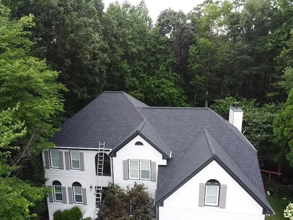 Finished dark shingle roof on a white two-story home in Woodstock, GA
