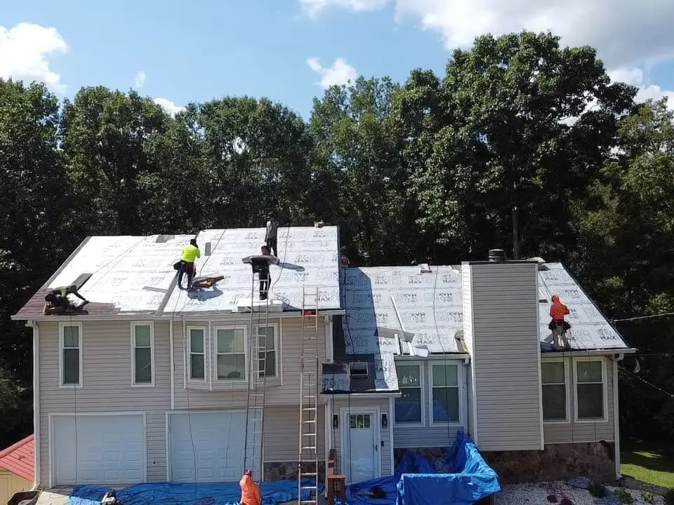 Roof replacement in progress on a Woodstock, GA home with the yard protected by tarps