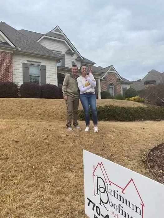 Happy Platinum Roofing customers standing in front of their newly roofed North Georgia home