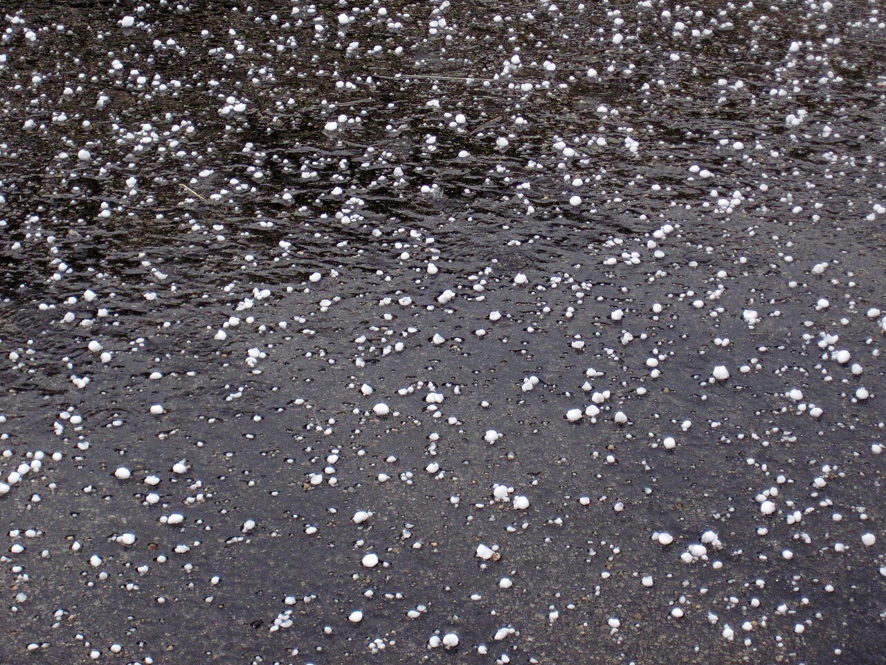 Hailstones scattered across dark pavement after a North Georgia storm