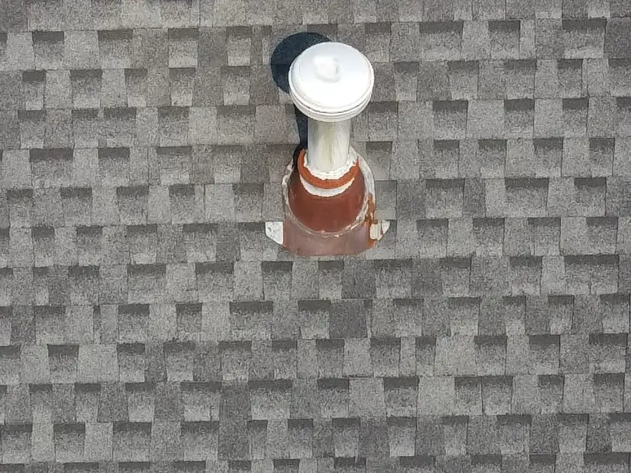 A worn pipe boot on an Alpharetta, GA roof, with a weathered, discolored rubber collar around the plumbing vent pipe